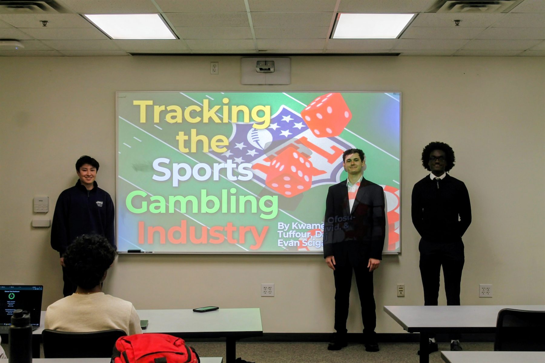 Three students presenting a project about tracking the sports gambling industry